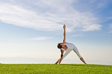 Young woman practising Hatha yoga, here the pose utthita parshvakonasana, side stretch