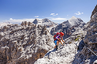 Climber, descent from the Southern Fanesspitze on the Via ferrata Tomaselli, behind the Tofana di Rozes, Tofana di Mezzo and Tofana di Dentro, Dolomites, Alps, Province of Belluno, Italy, Europe