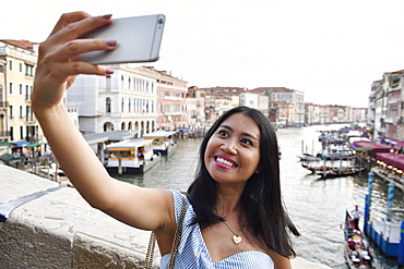 Woman taking a Selfie with mobile phone, Rialto bridge, Canale Grande, Venice, Venice, Venice, Italy, Europe