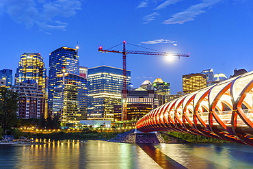 Calgary downtown at dusk with Peace Bridge over Bow river, Alberta, Canada, North America