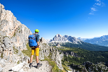 Hiker with climbing helmet on hiking trail to the Nuvolau, view of the mountain range Tofane, Dolomites, South Tyrol, Trentino-Alto Adige, Italy, Europe