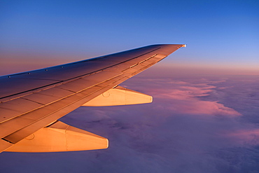 Wing of a plane, flight over clouds, dusk, sunset, Norway, Europe