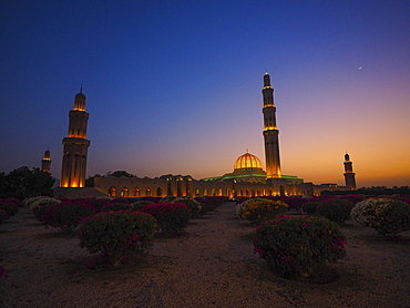 Evening atmosphere, illuminated Great Sultan Qabus Mosque, garden with rhododenderen, Muscat, Oman, Asia