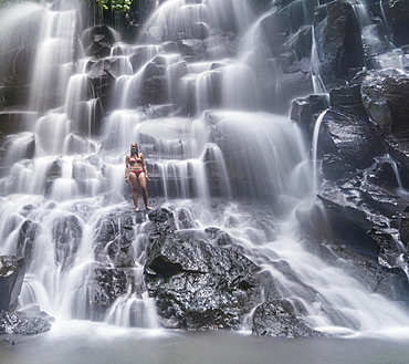 Woman standing in waterfall, Air Terjun Kanto Lampo, near Ubud, Bali, Indonesia, Asia