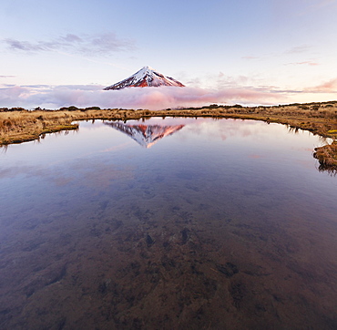 Reflection in Pouakai  Tarn lake, pink clouds around stratovolcano Mount Taranaki or Mount Egmont at sunset, Egmont National Park, Taranaki, New Zealand, Oceania