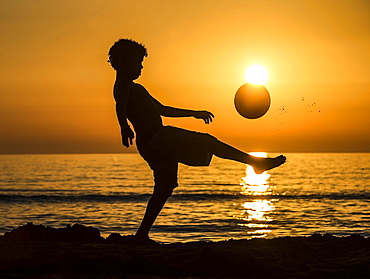 Boy with soccer ball, sunset at the sea, beach, Italy, Europe