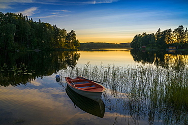 Lake and rowing boat at sunset in Bengtsfors, Dalsland, Sweden, Europe