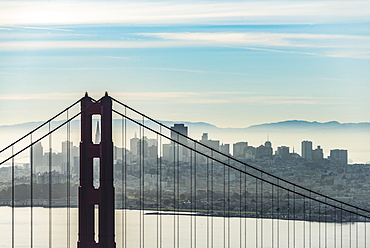 Golden Gate Bridge with skyline of San Francisco in the morning mist, California, USA, North America