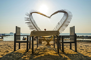 Laid table with a heart of palm fronds, sunset, Koh Samui, Gulf of Thailand, Thailand, Asia