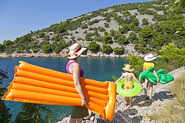 Woman and children on their way to the beach in a bay, near Donja Klada, Kvarner Gulf, Croatia, Europe