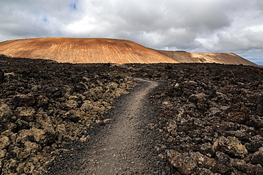 Path through a lava field, volcanic landscape, Fire Mountains, volcanoes, Caldera Blanca volcano at the back, Lanzarote, Canary Islands, Spain, Europe