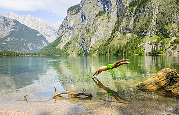 Young man jumps into Lake Obersee, swimming, mountain lake, mountain landscape, in the back Watzmann massif, Salet am Konigssee, Berchtesgaden National Park, Berchtesgadener Land, Upper Bavaria, Bavaria, Germany, Europe