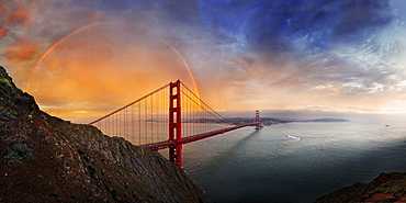 Panoramic view of the Golden Gate Bridge with a rainbow at sunset and orange-glowing storm clouds, San Francisco, California, United States, North America