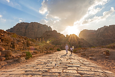 Two locals walk on Old Roman Road next to ruins of Petra, Nabataean city of Petra, near Wadi Musa, Jordan, Asia