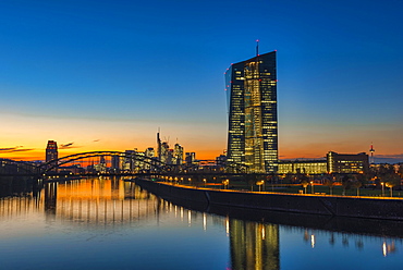 European Central Bank, ECB in front of the illuminated skyline, Osthafenbrucke, dusk, Frankfurt am Main, Hesse, Germany, Europe