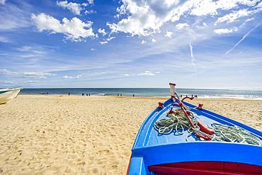 Blue, fishing boat on the sandy beach in Armacao de Pera, Algarve, Portugal, Europe