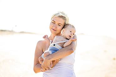 Happy mom with her cheerful son on the beach, Portugal, Europe