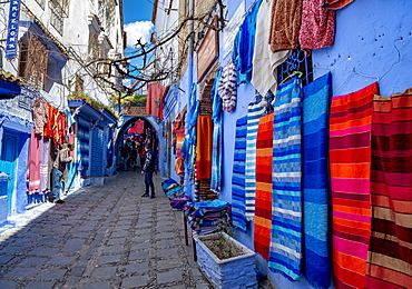 Colourful fabrics on a blue house wall, narrow alley, medina of Chefchaouen, Chaouen, Tanger-Tetouan, Morocco, Africa