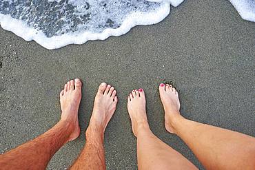 Two feet standing at the surf from the sea, Crete, Greece, Europe