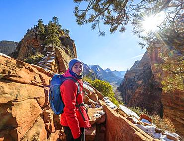 Young woman hiking on the via ferrata to Angels Landing, Angels Landing Trail, in winter, Zion Canyon, mountain landscape, Zion National Park, Utah, USA, North America