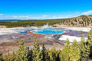 Visitors on footbridge over steaming hot spring with coloured mineral deposits, Grand Prismatic Spring, Midway Geyser Basin, Yellowstone National Park, Wyoming, USA, North America