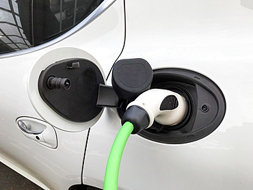 Charging plug on electric car, car being charged at charging station, Germany, Europe