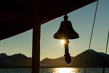 Ship's bell of a sailing ship, Silhouette in front of sun, Spitsbergen, Svalbard, Norway, Europe