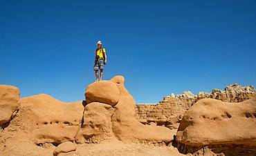 Tourist, young man likes Hodoo, eroded Hoodoos, rock formation of Entrada sandstone, Goblin Valley State Park, San Rafael Reef, Utah, southwest, USA, North America