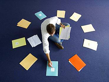 Man, applicants sorted, sitting in a circle between job offers, Germany, Europe