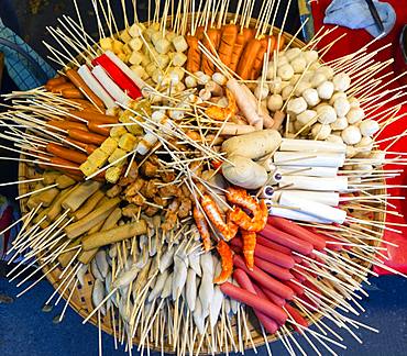 Various skewers with sausage and meat, meatballs, in bamboo basket at a market, Thai cuisine, Thailand, Asia