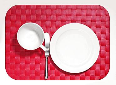 Cover, empty white plate and cup, knife on red placemat, optional, Germany, Europe