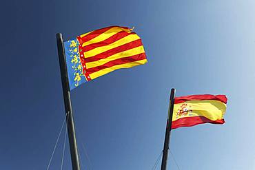 Two Spanish flags in the wind in front of blue sky, flag Valencia and flag Kingdom of Spain, Valencia, Spain, Europe