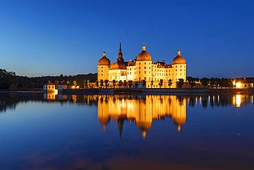 Illuminated Moritzburg Castle at dusk, water reflection in the lake, Saxony, Germany, Europe