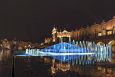 Illuminated fountain with cloth halls at night, market square, Krakow, Poland, Europe