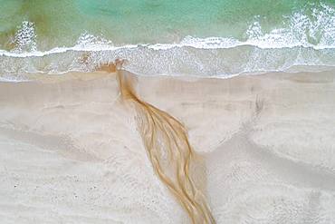 Creek with reddish ferruginous water flows over a sandy beach into the sea, near Stornoway, Lewis Island and Harris, Scotland, Great Britain, Great Britain