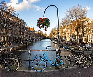 Parking bicycle on bridge over canal at Oudezijds Voorburgwal, behind Sint Nicolaaskerk, Sankt Nikolas church, Amsterdam, North Holland, Netherlands