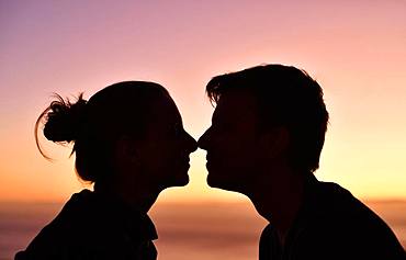 Young couple, lovers, nose to nose, silhouette, face to face, at sunset, Madeira Island, Portugal, Europe