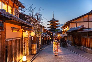 Woman in kimono in a lane, Yasaka dori historical alleyway in the old town with traditional Japanese houses, behind five-storey Yasaka pagoda of the Buddhist Hokanji temple, evening mood, Kyoto, Japan, Asia