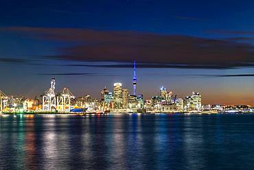 Illuminated skyline of Auckland at sunset, Waitemata Harbour, Sky Tower, Central Business District, Auckland, North Island, New Zealand, Oceania