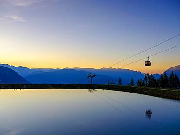 Alpine panorama, gondola of the Jennerbahn cable car reflected in the evening light in an artificial mountain lake, Jenner, Berchtesgadener Alps, Schoenau am Koenigssee, Berchtesgadener Land, Upper Bavaria, Bavaria, Germany, Europe