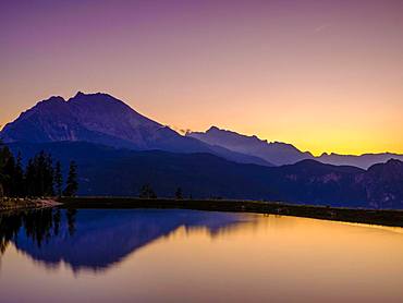 Mountain silhouettes reflected in an artificial mountain lake at sunset, Watzmann, Hochkalter, Berchtesgaden Alps, Berchtesgaden National Park, Schoenau am Koenigssee, Berchtesgadener Land, Upper Bavaria, Bavaria, Germany, Europe