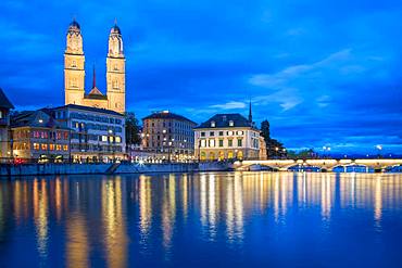 View over the river Limmat at dusk, church Grossmuenster and Lake Zurich in the background, old town, Zurich, Switzerland, Europe