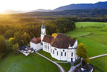 Wieskirche at sunrise, pilgrimage church to the Scourged Saviour on the Wies, Wies, near Steingaden, Pfaffenwinkel, aerial view, Upper Bavaria, Bavaria, Germany, Europe