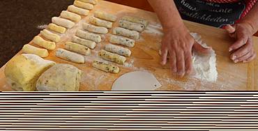 Hands rolling potato dough on wooden board with flour, Bavaria, Germany, Europe