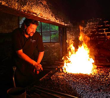 Blacksmith at the blacksmith's hearth, hammer mill Burghausen, Upper Bavaria, Bavaria, Germany, Europe