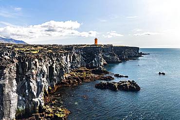 Orange lighthouse of Oendverdarnes stands on cliffs, lava rocky coast, Oendveroarnes, Snaefellsjoekull National Park, Snaefellsnes Peninsula, Snaefellsnes, Vesturland, Iceland, Europe