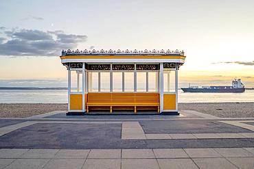 Yellow vintage bus stop by the sea in Portsmouth, Great Britain