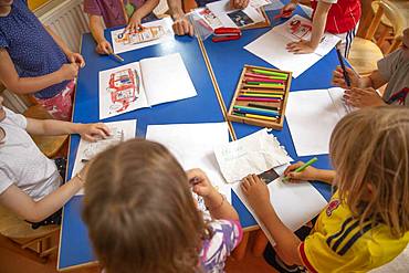 Children painting in kindergarten with crayons, Cologne, North Rhine-Westphalia, Germany, Europe