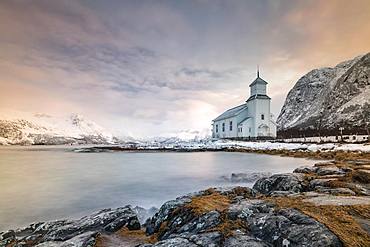 Church of Gimsoy in front of snowy mountains, Gimsoykirke, Gimsoy, Lofoten, Norway, Europe