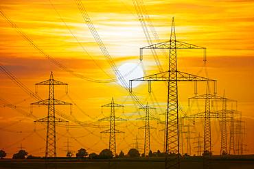 Overhead power lines, high voltage pylons, power lines, setting sun, Baden-Wuerttemberg, Germany, Europe